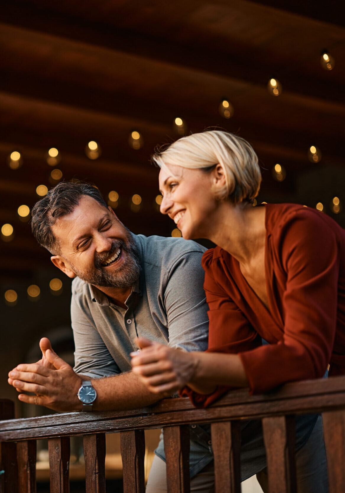 Happy mid adult couple talking on a terrace.
